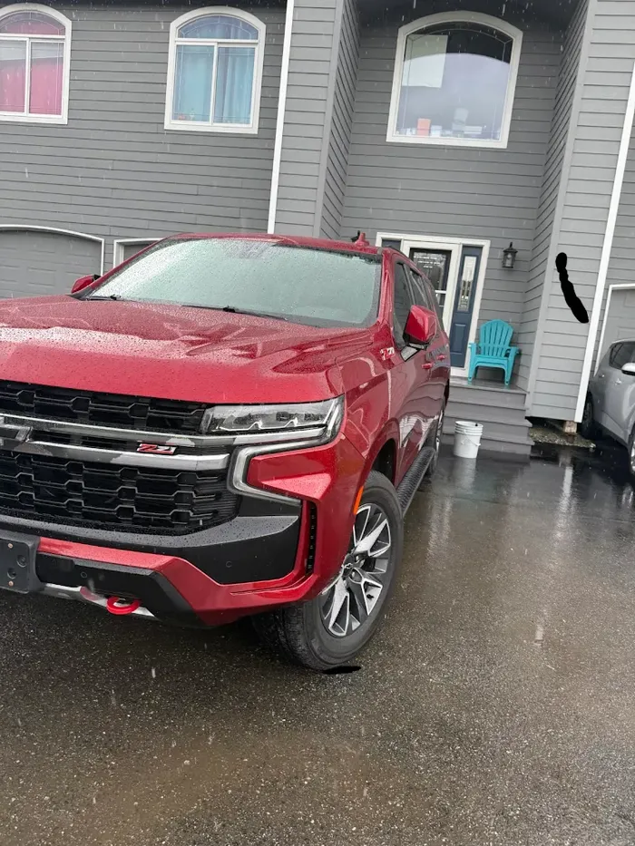 Red Chevy Tahoe getting a mobile detail in an Anchorage driveway