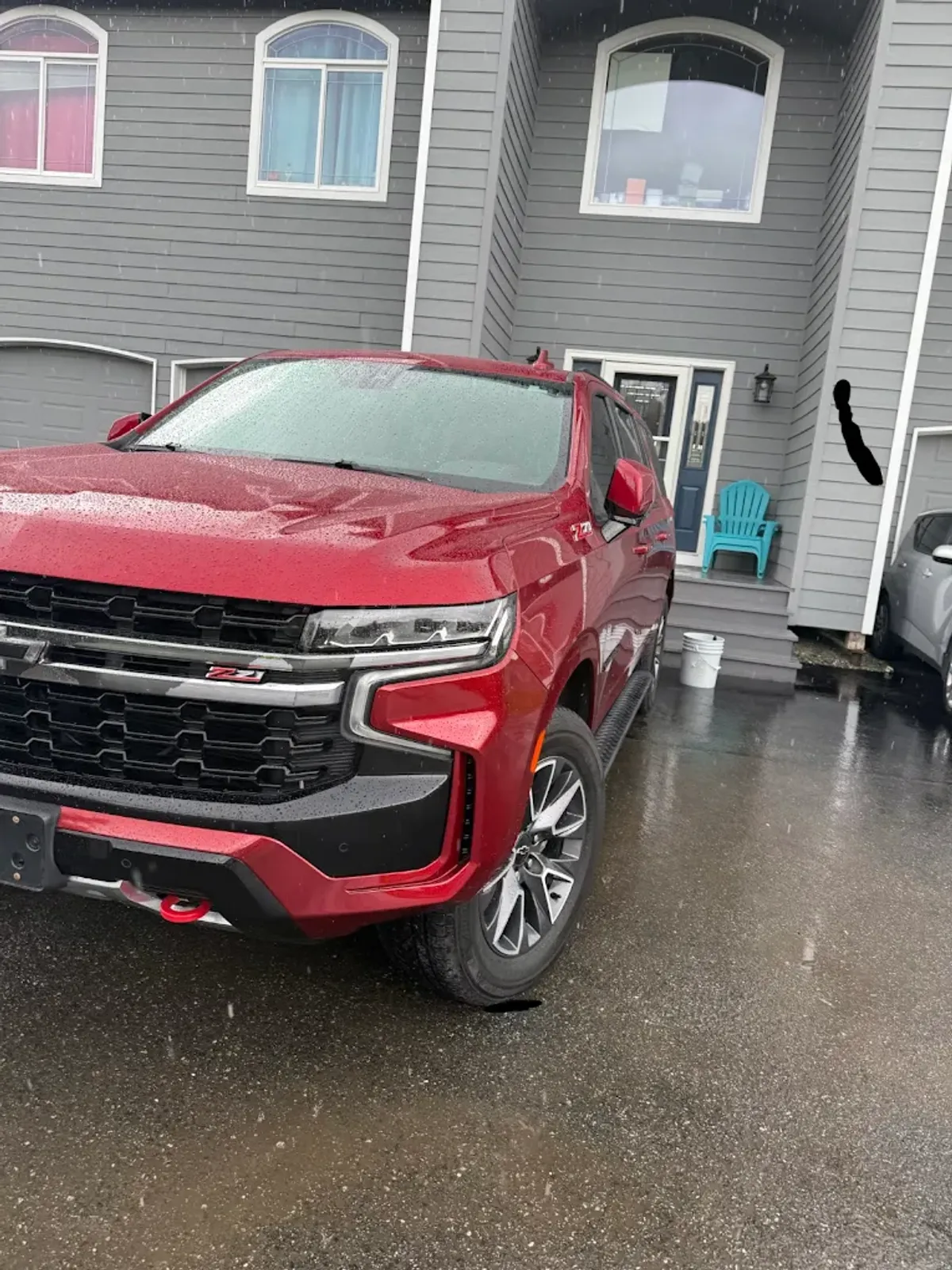 Red Chevy Tahoe getting a mobile detail in an Anchorage driveway